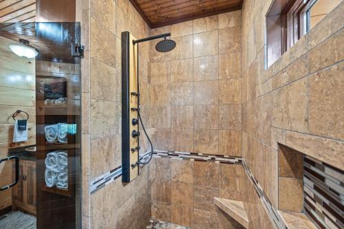a bathroom with a shower with a stone wall at High Fa-Lootin by American Patriot Getaways in Oldham