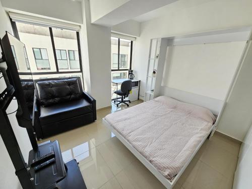 a small bedroom with a bed and a chair at Habitación con baño privado en departamento compartido cerca de zona de conciertos in Mexico City