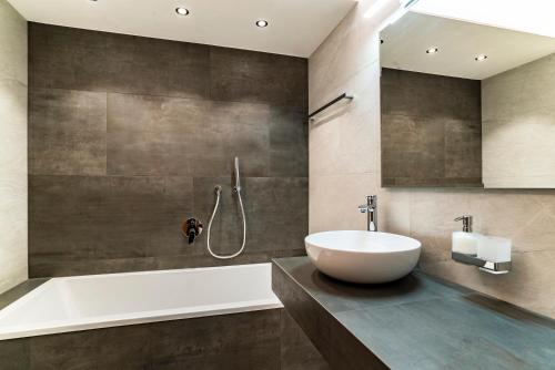 a bathroom with a sink and a bath tub at Villa Erina in Ortisei
