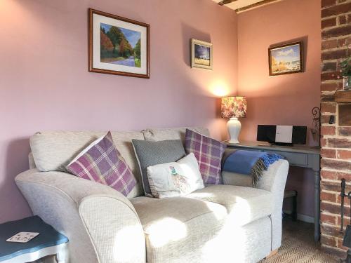 a living room with a couch and a desk at Beehive Cottage in Wittersham