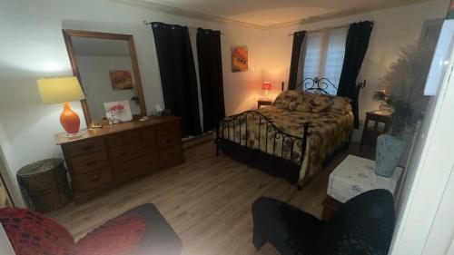 una camera da letto con un letto, un comò e uno specchio di Paradise Eastern Township cottage a Cowansville