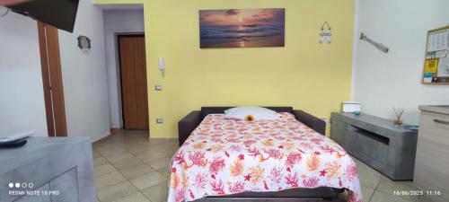 a bedroom with a bed with a floral bedspread at Domos Sa Murta in Solanas