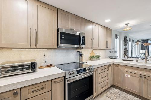 a kitchen with wooden cabinets and a microwave at Tranquillity on 30A Unit# 210 by 30A Escapes in Seacrest