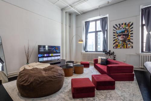 a living room with a red couch and a tv at 4 Stylish Lofts in Old Montreal in Montréal