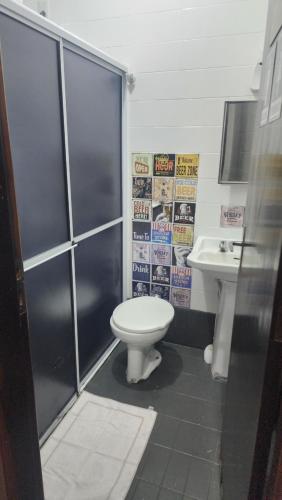a bathroom with a toilet and a sink at Hostel Lumaria 1 in Blumenau