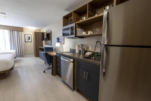 a kitchen with a refrigerator and a sink in a room at Sonesta ES Suites Lafayette Airport Extended Stay in Lafayette