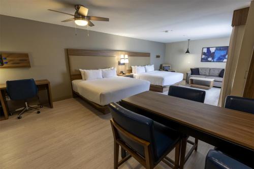 a hotel room with two beds and a table at Sonesta ES Suites Lafayette Airport in Lafayette