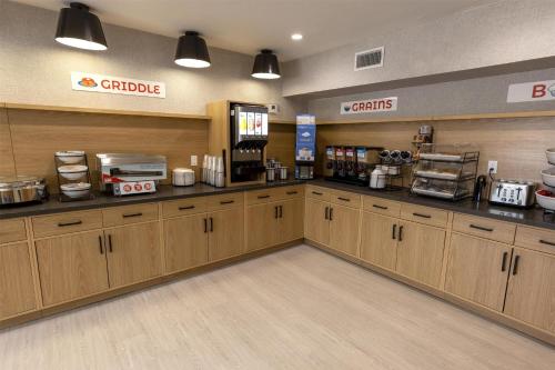 una cafetería con armarios de madera y una barra en Sonesta ES Suites Lafayette Airport Extended Stay, en Lafayette