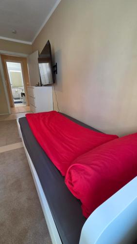 a bed with a red blanket on top of it at 3Raumwohnung mit Balkon in Leipzig Nord BMW, Amazon, Messe & Porsche in Taucha