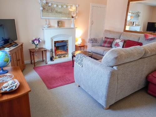 a living room with a couch and a fire place at Tradewinds in Portknockie