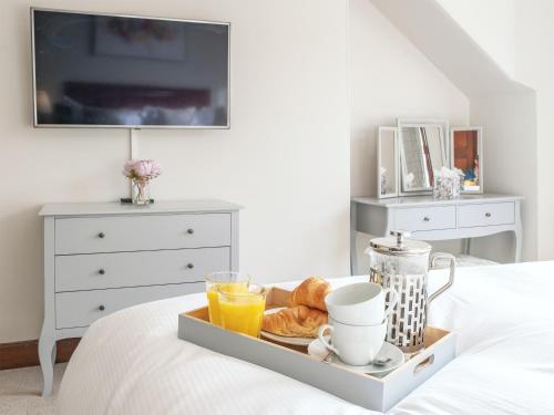 a tray of breakfast foods and orange juice on a bed at Blair Terrace in Portpatrick