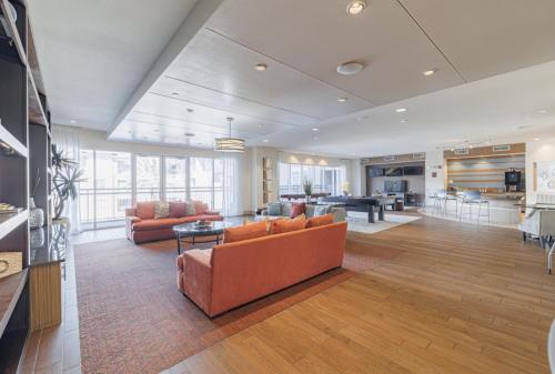 a living room with orange couches and a table at Gorgeous Furnished Apartments near Texas Medical Center & NRG Stadium in Houston