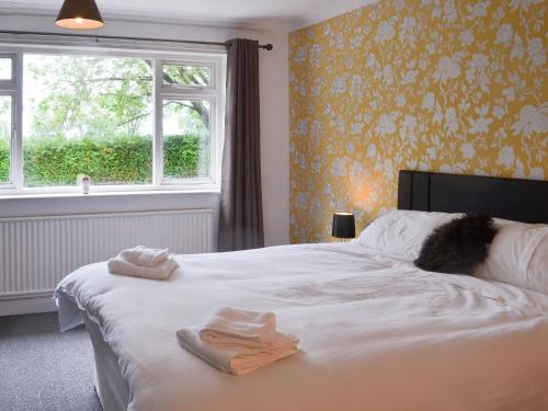 a bedroom with a bed with towels on it at Glebe Farm Bungalow in Market Rasen