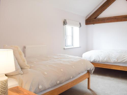 a bedroom with two beds and a window at The Dairy - Uk34564 in Whitchurch
