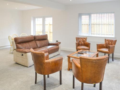 Una sala de estar con un sofá y sillas y una mesa. en Forest Close, en Forest Hall