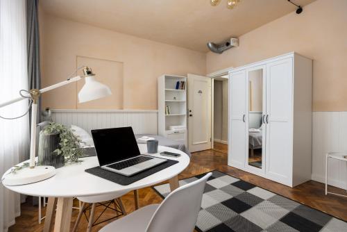 a room with a white table with a laptop on it at 1800 by Vince Stay - Private Rooms in Town Hall Square in Tartu