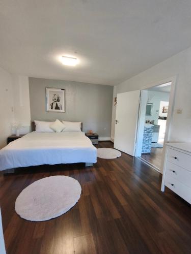 a bedroom with a large white bed and wooden floors at FeWo Goslar Harz in Goslar