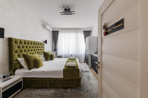 a bedroom with a large bed with a green headboard at Eden Central Boutique Suites - Garden & Spacious Apartments in Cluj-Napoca