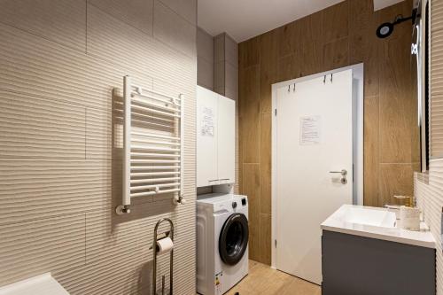 a bathroom with a washing machine and a sink at Sika Regal Apartment Arad - private garden & parking - self check-in in Arad