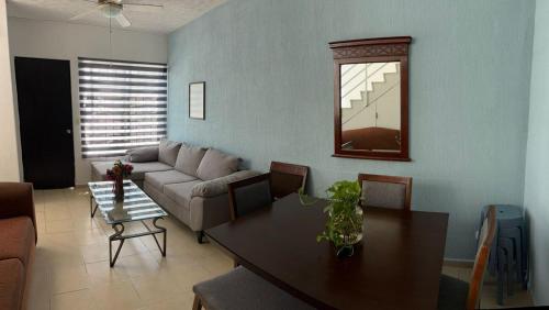 a living room with a couch and a table at Casa para 7, con clima y con albreca en fraccionamiento privado in Cancún
