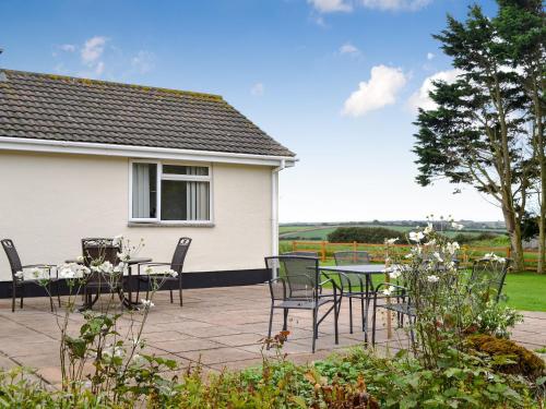 a patio with a table and chairs in front of a house at Tregoona in Crantock