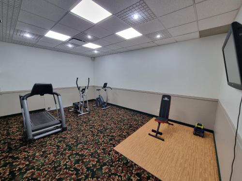 a room with a gym with a treadmill and a television at Travelodge by Wyndham Trois-Rivieres in Trois-Rivières