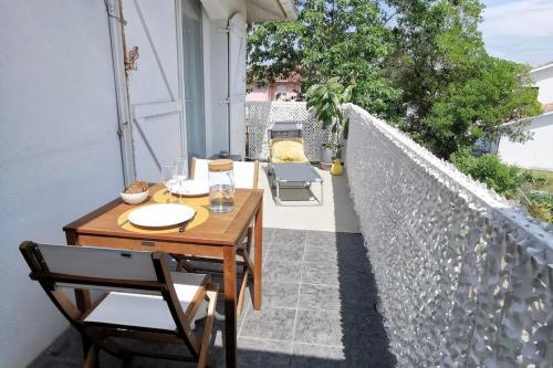 a patio with a table and chairs on a balcony at Charming apartment with south terrace in Labenne