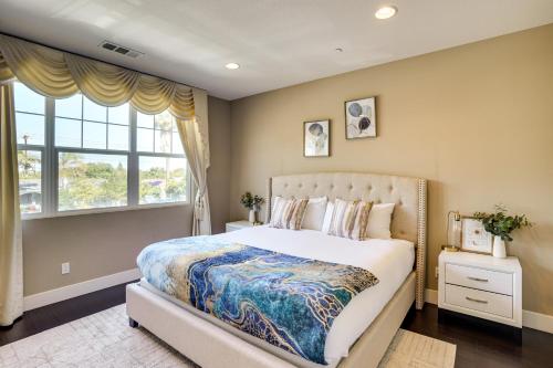 ein Schlafzimmer mit großem Bett und Fenster in der Unterkunft 3 Mi to Disneyland Home with Hot Tub and Game Room in Anaheim