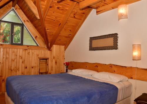 a bedroom with a large bed in a wooden cabin at Aparts La Balconada by DOT Suites in Villa Pehuenia