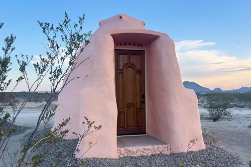 ein kleines Haus mit einer Tür in der Wüste in der Unterkunft Sanadora - Organic Earthern Desert Domes - Sustainable Stays Under the Stars in Terlingua