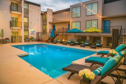 a pool at a hotel with chairs and umbrellas at Worldcup Ready DT DFW Chic Free Parking and Pool In Medical District in Dallas