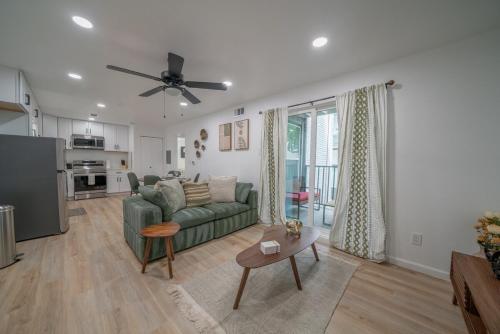 a living room with a green couch and a table at Worldcup Ready DT DFW Chic Free Parking and Pool In Medical District in Dallas