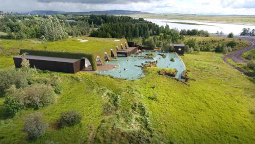 an aerial view of a building on a grassy hill at Enchanting country home in Laugaras