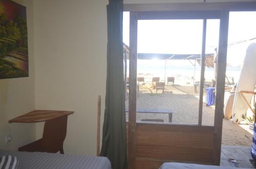 a bedroom with a door leading to a beach at My Beach House - Lombok - Kuta - Areguling beach in Kuta Lombok