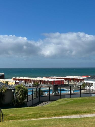 a view of a resort with the ocean in the background at Departamento Miramar 6 personas costanera in Miramar