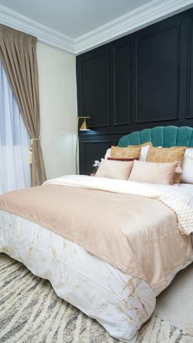 a bedroom with a large bed with a black headboard at Tériya House in Dakar