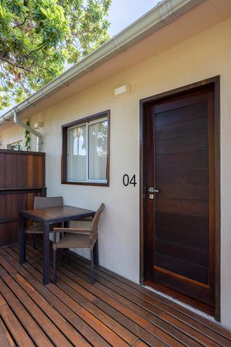 a wooden door and a table on a deck at Pousada Lua Bela in Fernando de Noronha