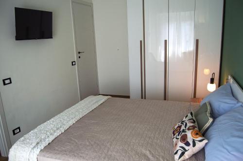 a bedroom with a bed and a tv on the wall at Iris House in Ferrara