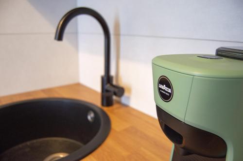 a kitchen with a sink and a green mixer at Iris House in Ferrara