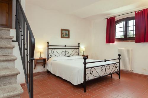 a bedroom with a bed and a staircase with red curtains at Giovanni in Rapale