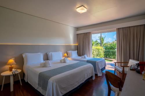 a hotel room with two beds and a large window at Pousada Lua Bela in Fernando de Noronha