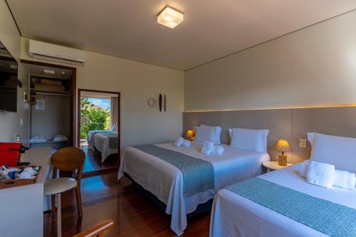 a hotel room with two beds and a bathroom at Pousada Lua Bela in Fernando de Noronha