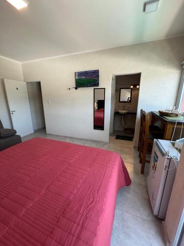 a bedroom with a large red bed and a table at Apart Flamingos in Miramar