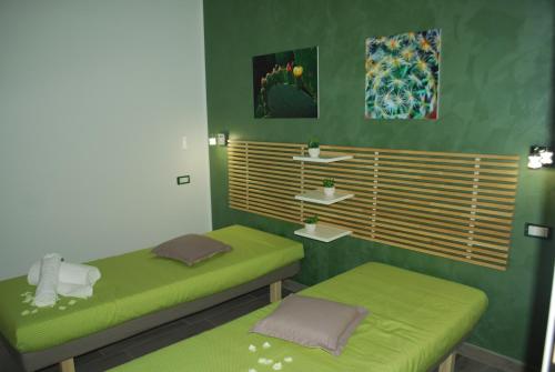 two beds in a room with green walls at B&B Aurora in Custonaci