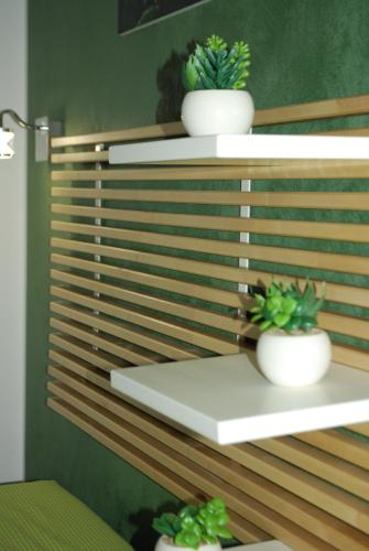 a shelf with three potted plants on it at B&B Aurora in Custonaci
