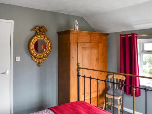 a bedroom with a bed and a mirror on the wall at Heath View in Saxmundham