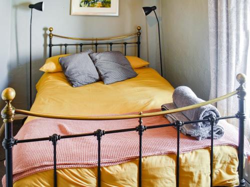 a bed with a metal frame with two pillows on it at Heath View in Saxmundham