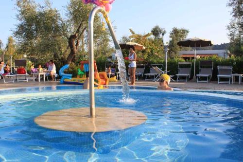 a fountain in a swimming pool with people playing at Apartment in Vieste - Apulien 20886 in Lupetto