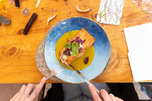 a person holding a plate with a slice of pizza at Hotel Don Raul in San Pedro de Atacama