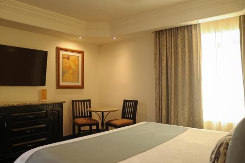 a hotel room with a bed and a table and chairs at Hotel Ticuán in Tijuana
